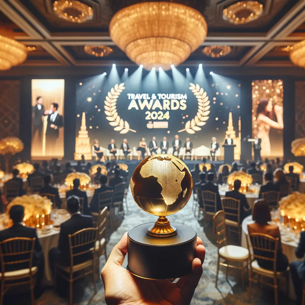 Travel & Tourism Awards 2024 ceremony in a grand ballroom with a person holding a globe-shaped golden trophy.